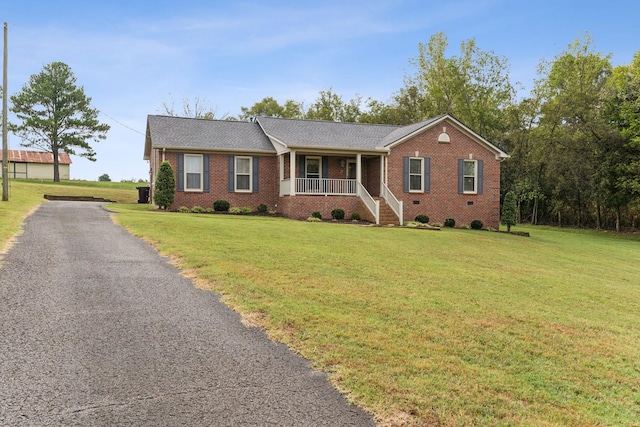 single story home featuring covered porch, a front lawn, and brick siding