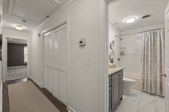 hallway with attic access, visible vents, baseboards, marble finish floor, and crown molding