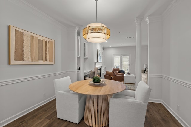 dining space with visible vents, baseboards, dark wood finished floors, ornate columns, and a fireplace