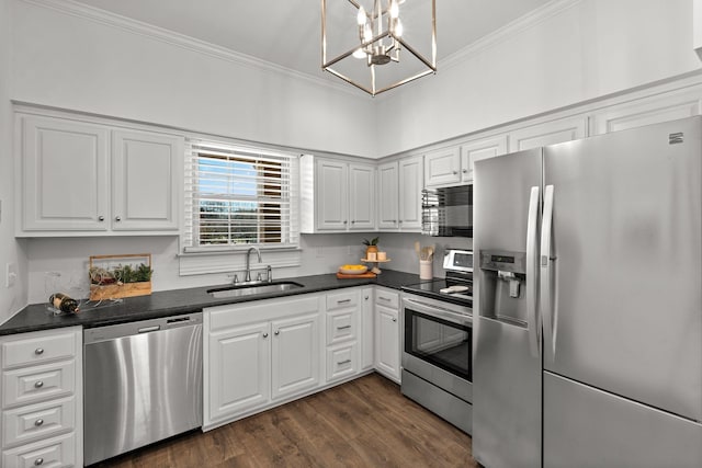 kitchen with stainless steel appliances, dark countertops, a sink, and ornamental molding