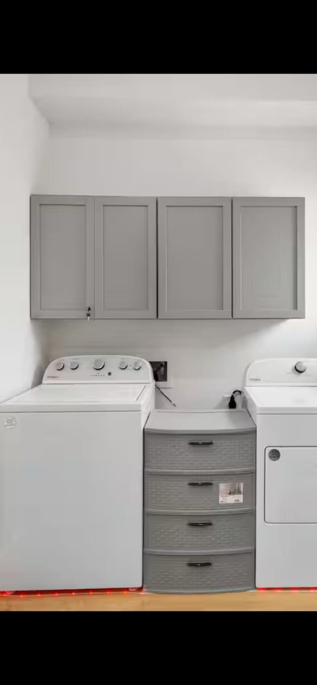 clothes washing area featuring cabinet space