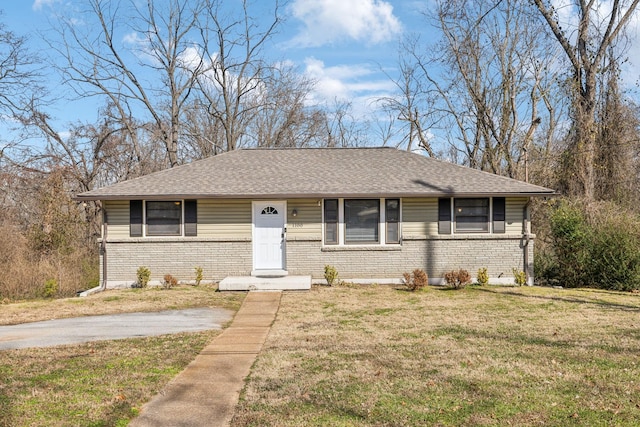 view of front of home with a shingled roof, brick siding, and a front lawn