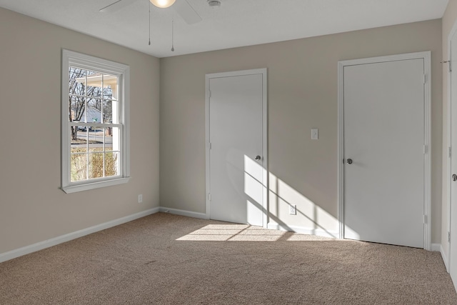 unfurnished bedroom featuring carpet, baseboards, and ceiling fan