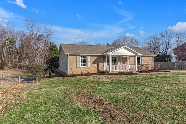 ranch-style house with covered porch, brick siding, a front lawn, and fence