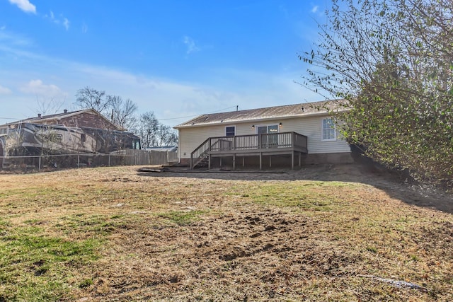 rear view of house featuring a deck, a yard, stairway, and fence