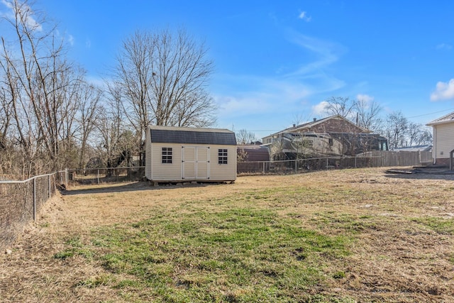 view of yard with a fenced backyard, an outdoor structure, and a shed