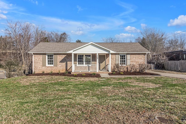 single story home featuring covered porch, a front yard, fence, and brick siding