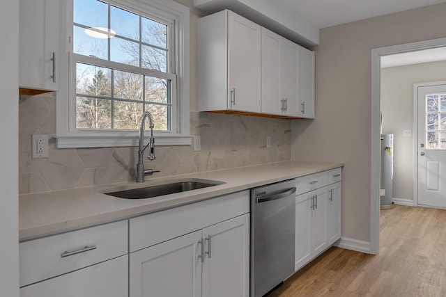 kitchen featuring a sink, white cabinets, light countertops, decorative backsplash, and dishwasher