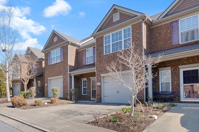 view of front of house with driveway, brick siding, and an attached garage