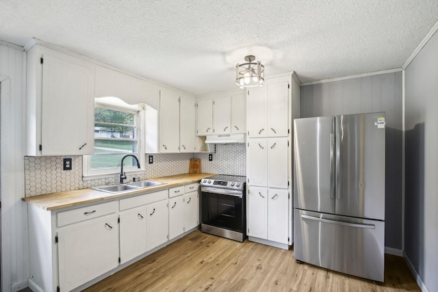 kitchen featuring under cabinet range hood, a sink, white cabinets, light wood-style floors, and appliances with stainless steel finishes