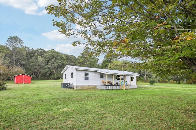 view of front of home with an outbuilding, a shed, crawl space, and a front lawn