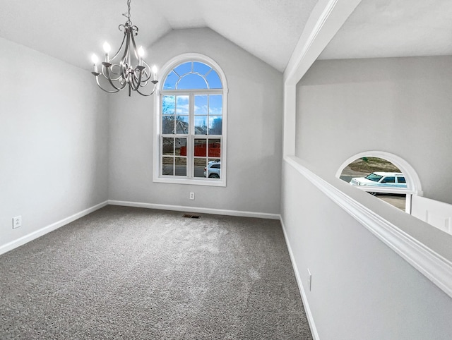 empty room with lofted ceiling, visible vents, carpet flooring, a chandelier, and baseboards