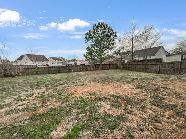 view of yard featuring a fenced backyard and a residential view