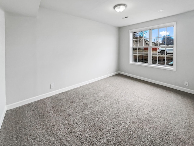 carpeted empty room featuring visible vents and baseboards