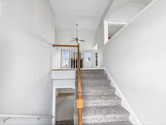 stairs featuring high vaulted ceiling, carpet flooring, baseboards, and a ceiling fan