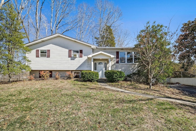 view of front of home with a front yard, brick siding, and fence