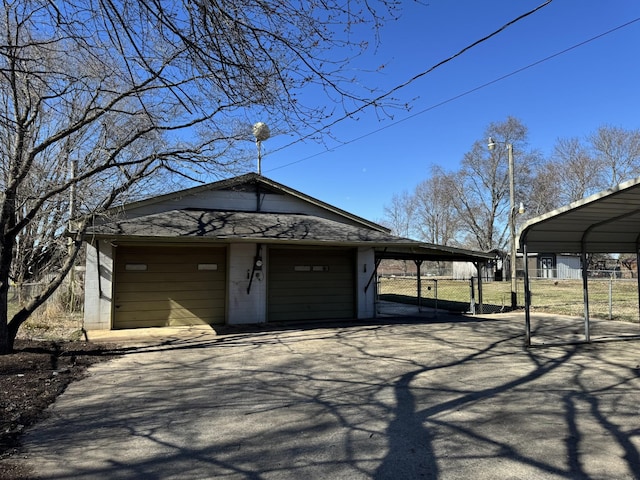 exterior space with a carport, a gate, fence, and aphalt driveway