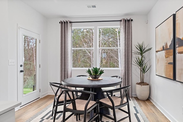 dining area with baseboards and light wood-style floors