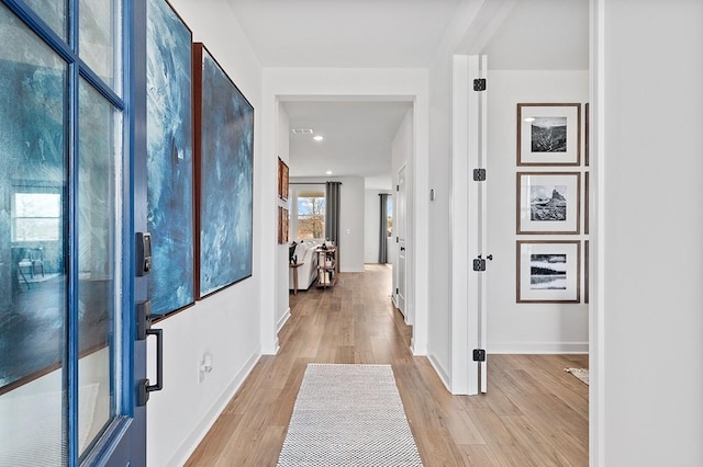 hallway featuring baseboards and wood finished floors