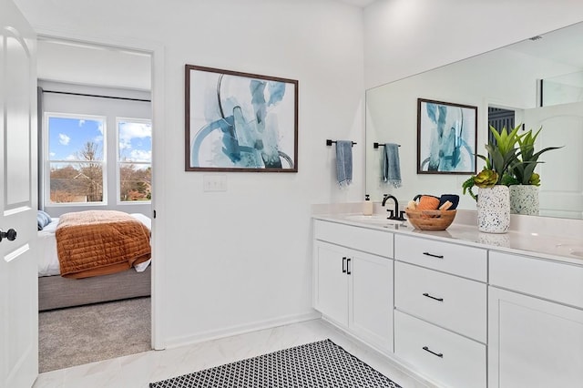 bathroom with baseboards, marble finish floor, ensuite bath, and vanity