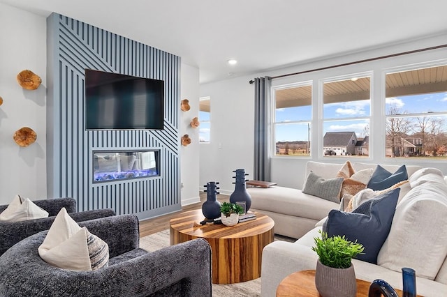 living area featuring recessed lighting, baseboards, wood finished floors, and a fireplace