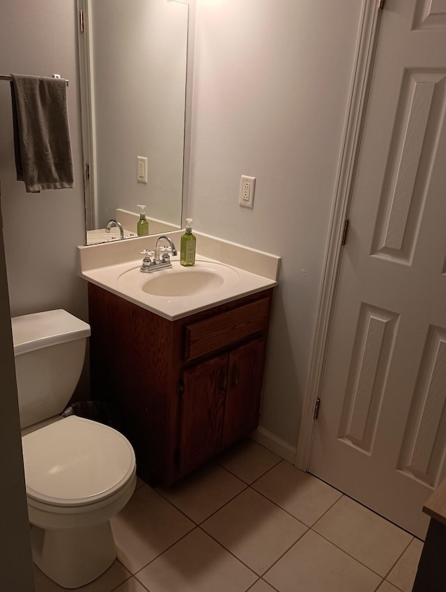 half bath featuring toilet, tile patterned flooring, and vanity