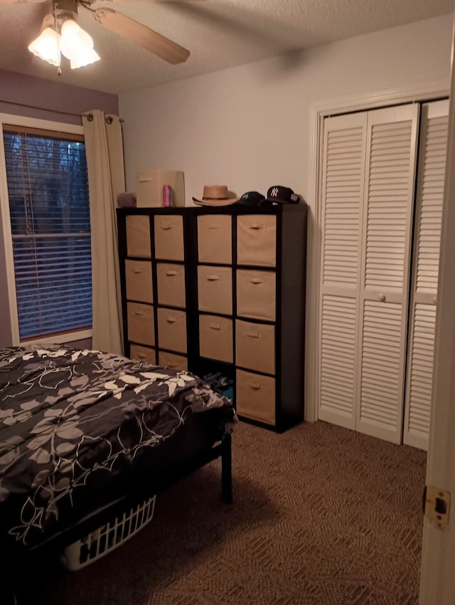 carpeted bedroom featuring a textured ceiling, a ceiling fan, and a closet