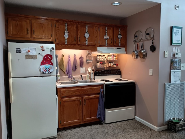 kitchen featuring freestanding refrigerator, under cabinet range hood, brown cabinets, and electric range