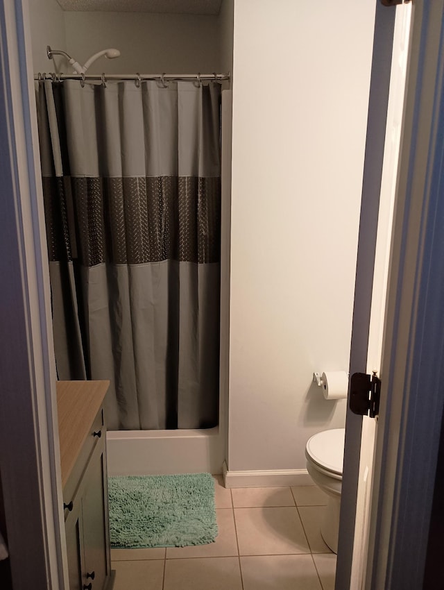 full bathroom featuring curtained shower, toilet, vanity, baseboards, and tile patterned floors