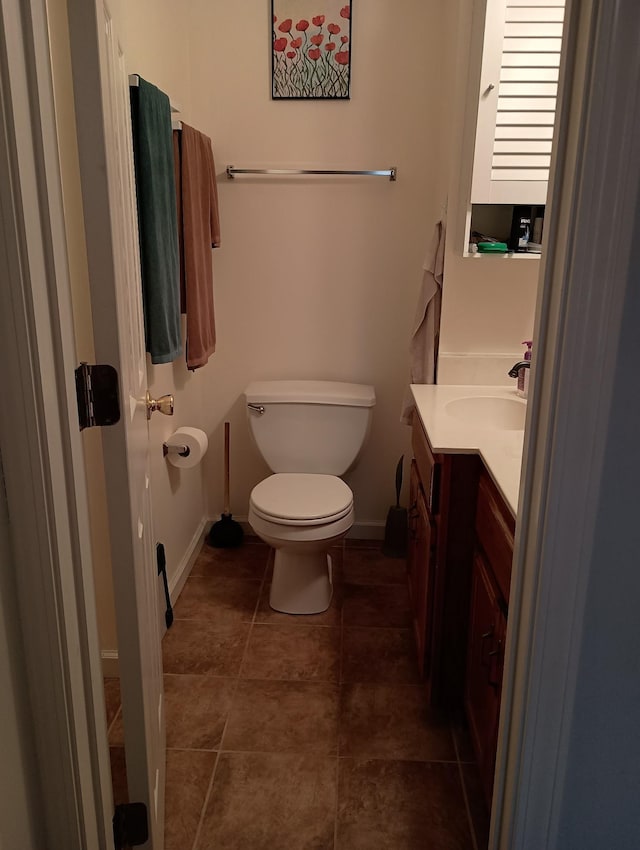 bathroom with baseboards, vanity, toilet, and tile patterned floors