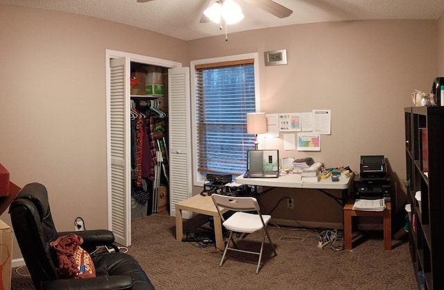 carpeted office space featuring a textured ceiling and a ceiling fan