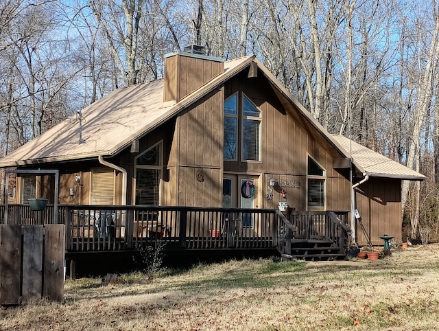 view of front of house featuring a chimney, metal roof, and a front yard