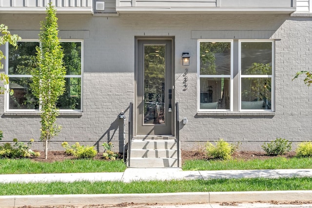 entrance to property featuring brick siding