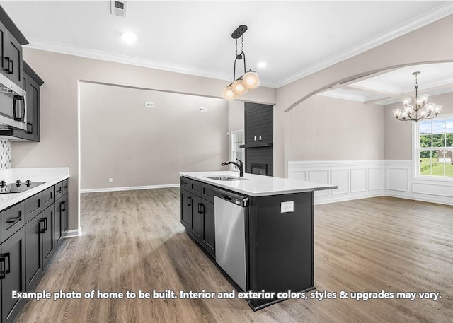 kitchen with stainless steel appliances, light countertops, ornamental molding, and light wood-style flooring