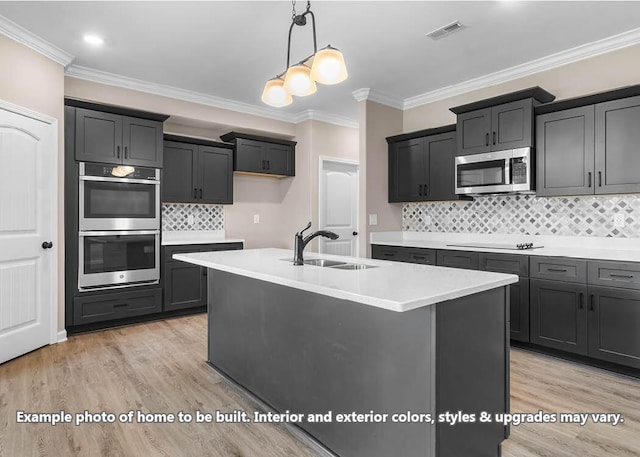 kitchen featuring light countertops, visible vents, appliances with stainless steel finishes, a sink, and light wood-type flooring