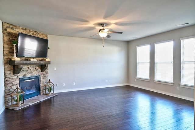 unfurnished living room with dark wood-style flooring, a fireplace, visible vents, and a healthy amount of sunlight