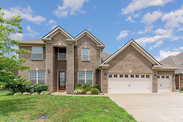 view of front of property featuring a garage, driveway, brick siding, and a front yard