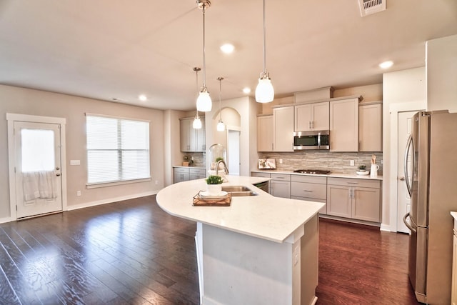 kitchen with a sink, stainless steel appliances, backsplash, and light countertops