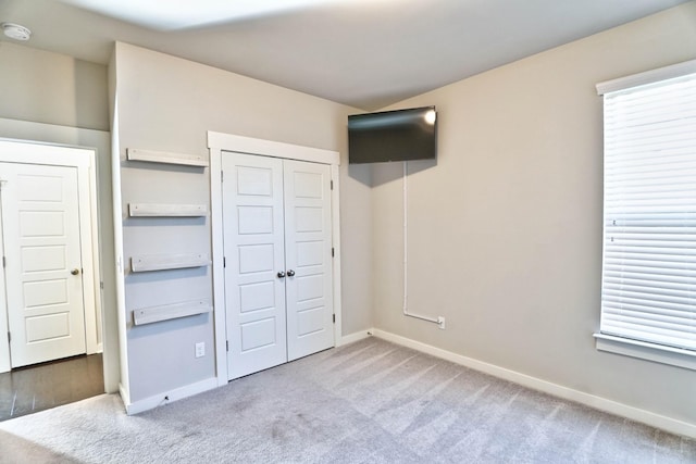 unfurnished bedroom featuring a closet, carpet flooring, and baseboards