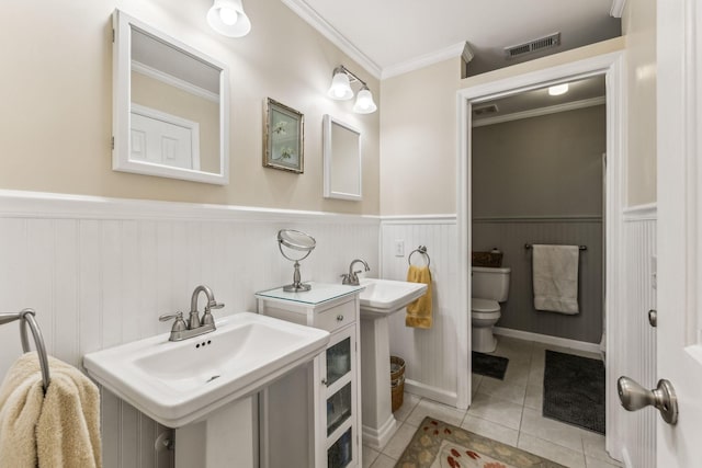 bathroom featuring visible vents, wainscoting, toilet, ornamental molding, and tile patterned floors