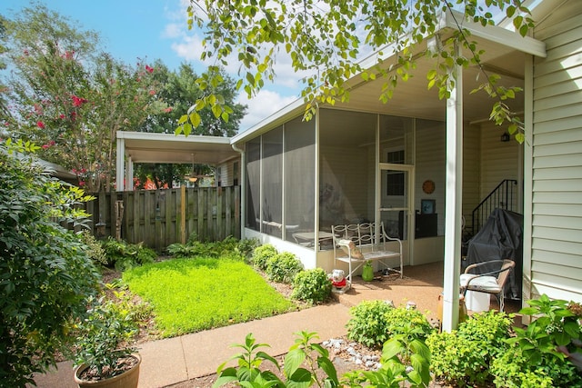 exterior space featuring fence and a sunroom