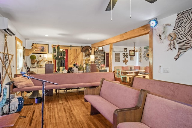 playroom featuring recessed lighting, wood finished floors, a wall mounted air conditioner, and a barn door