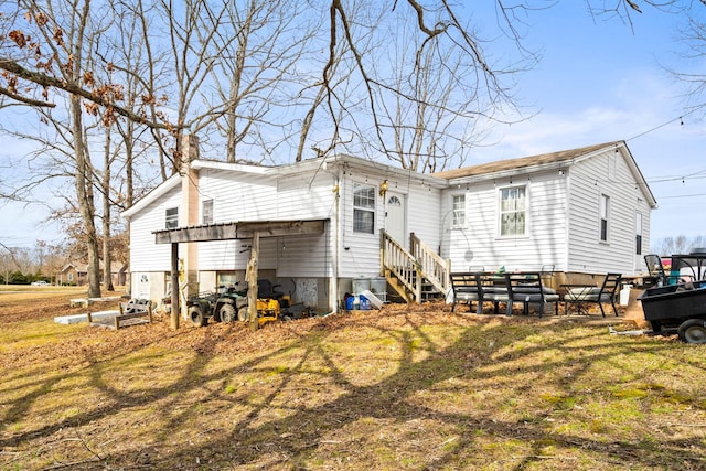 rear view of property with entry steps and a chimney