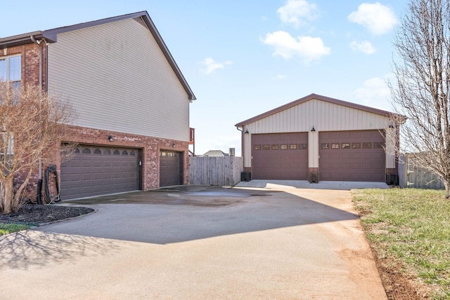 view of property exterior with brick siding, an outdoor structure, and fence