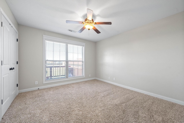 unfurnished bedroom featuring carpet flooring, a ceiling fan, visible vents, baseboards, and a closet