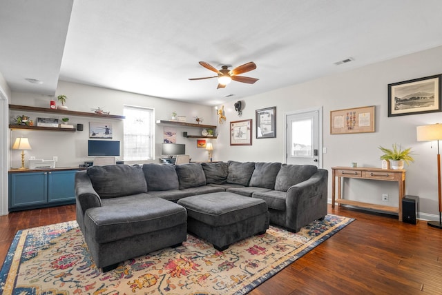 living area with ceiling fan, dark wood finished floors, visible vents, and baseboards