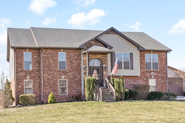 view of front of property featuring a shingled roof, brick siding, and a front lawn