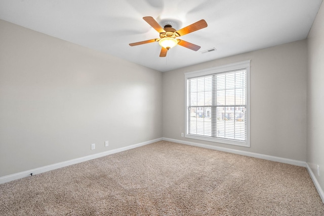 empty room featuring carpet, visible vents, ceiling fan, and baseboards