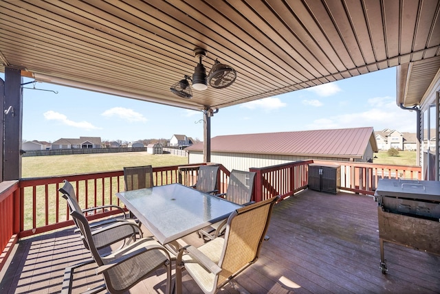 wooden deck with a yard, outdoor dining space, a residential view, and a ceiling fan