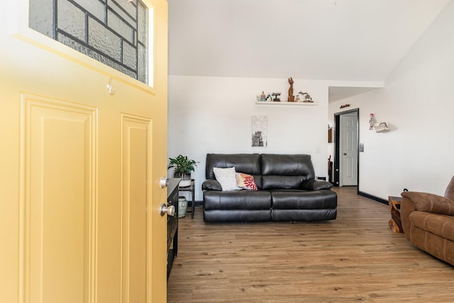 living room with baseboards, high vaulted ceiling, and wood finished floors